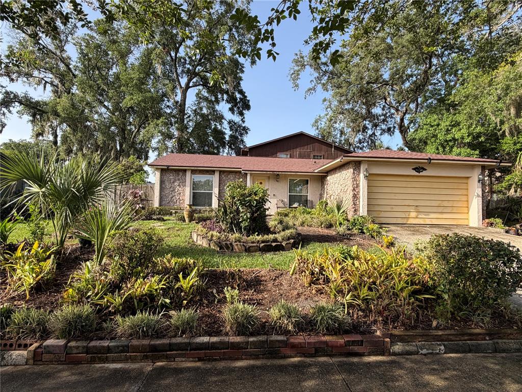 A single-story house with a stone facade, a two-car garage, and a landscaped front yard — 5832 ELON DRIVE, ORLANDO, FL