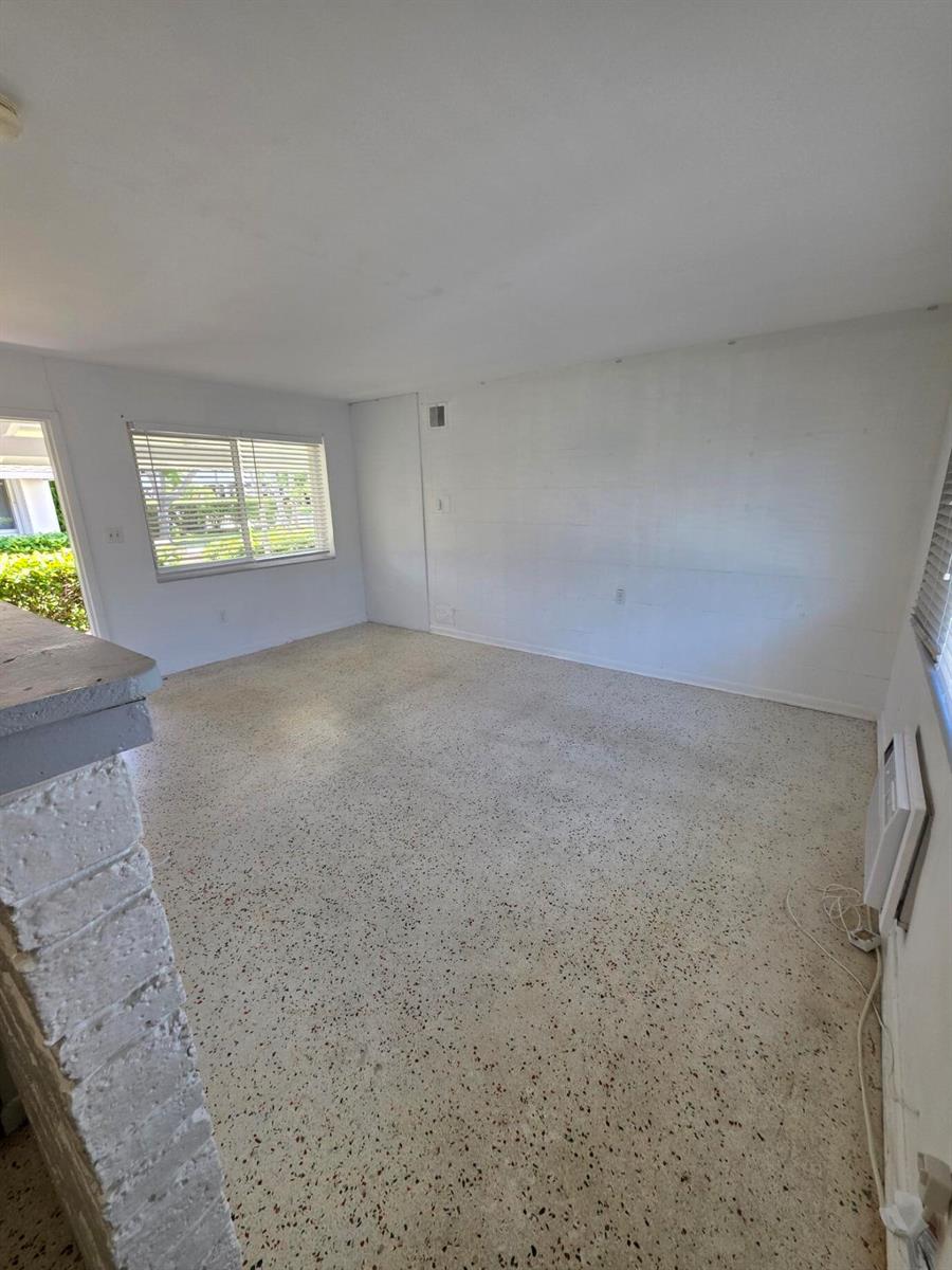An empty room features white walls, a window with blinds, and speckled terrazzo flooring — 1216 Cabana Road # 1a, Singer Island FL 33404, SINGER ISLAND, FL