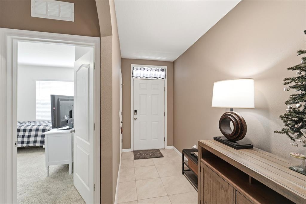 A tiled entryway leads to a white front door with a transom window above — 121 OLD MILL POND ROAD, EDGEWATER, FL