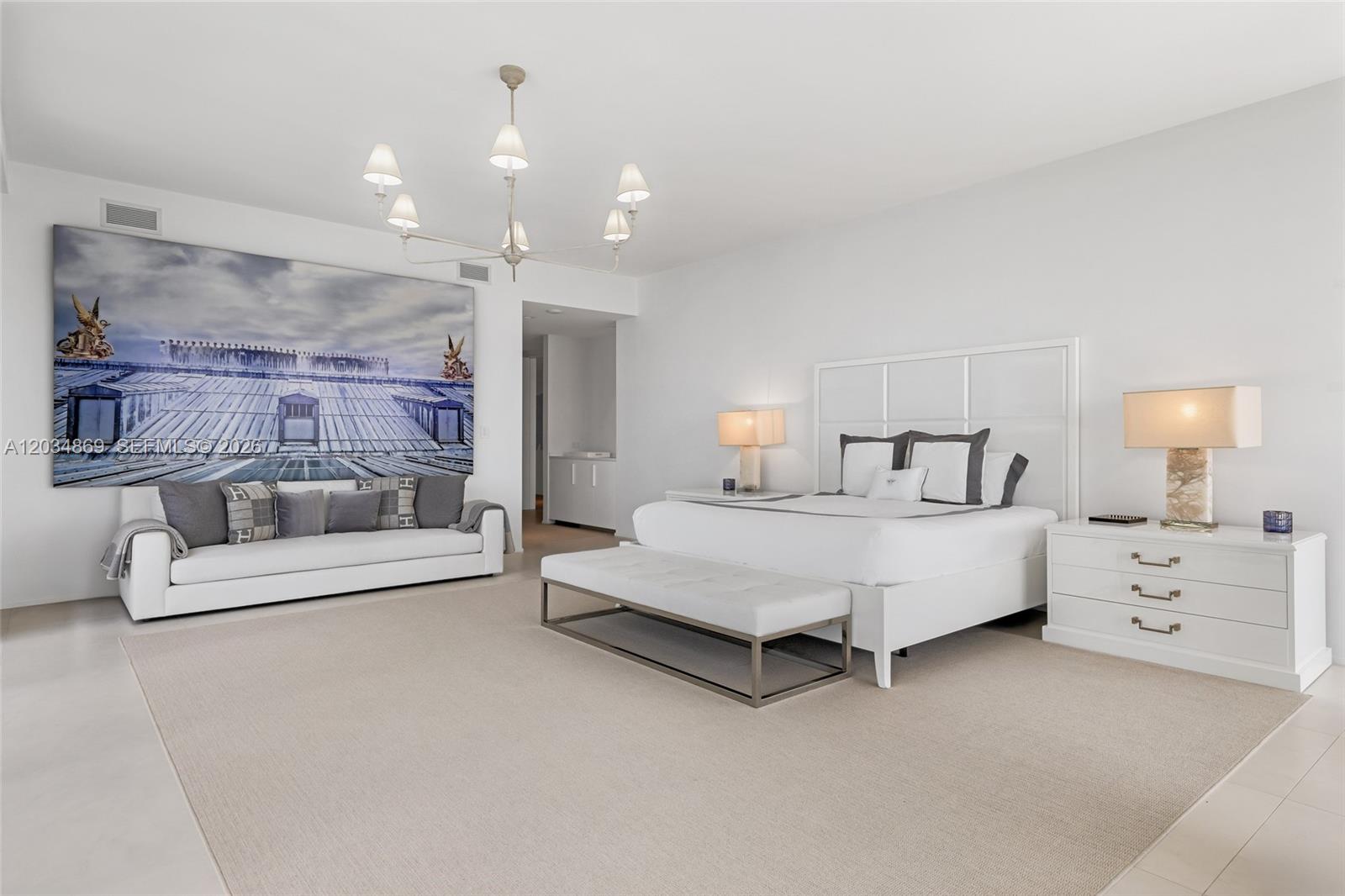 A spacious, minimalist bedroom features a large bed, a sofa, and a modern chandelier — 1000 Biscayne Blvd # 3701, Miami FL 33132, MIAMI, FL