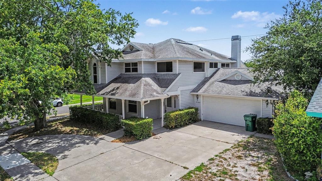 A two-story house with light gray siding, a shingled roof, and a concrete driveway — 9160 136TH WAY, SEMINOLE, FL