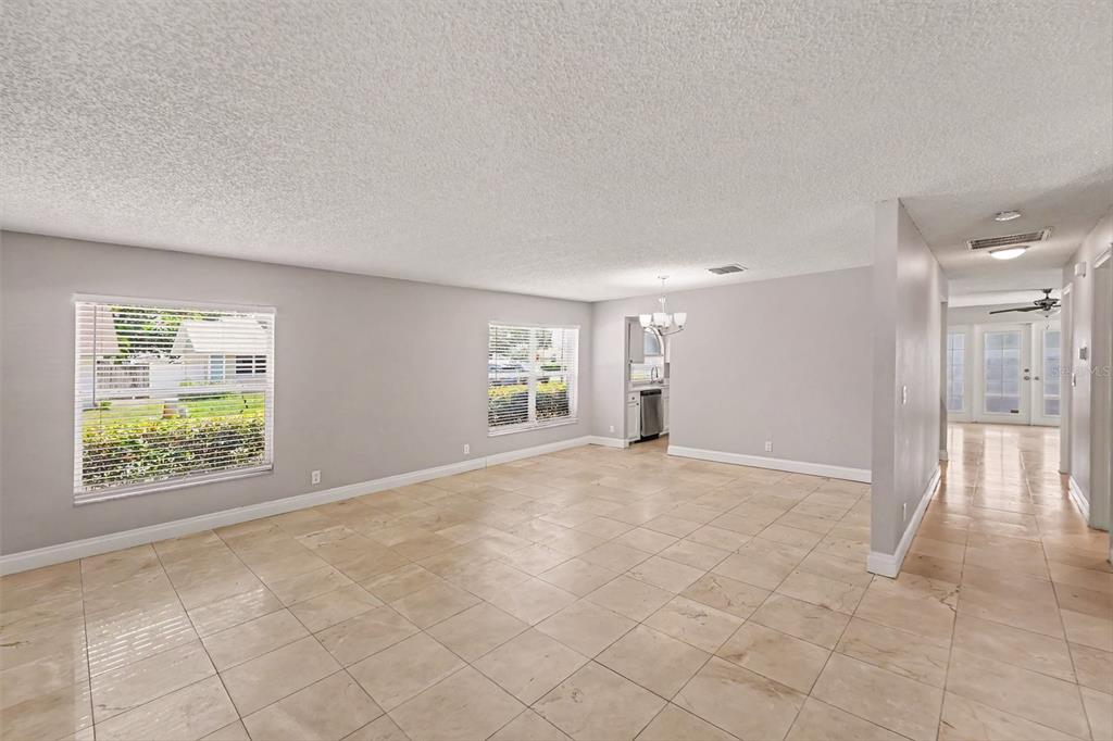 An open-concept living area features light gray walls, beige tile flooring, and two windows — 9160 136TH WAY, SEMINOLE, FL