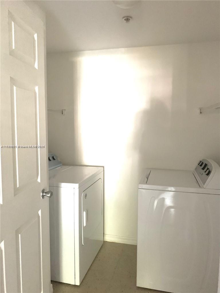A laundry room contains a white washing machine and a white dryer — 6776 W Sample Rd # 6776, Coral Springs FL 33067, CORAL SPRINGS, FL