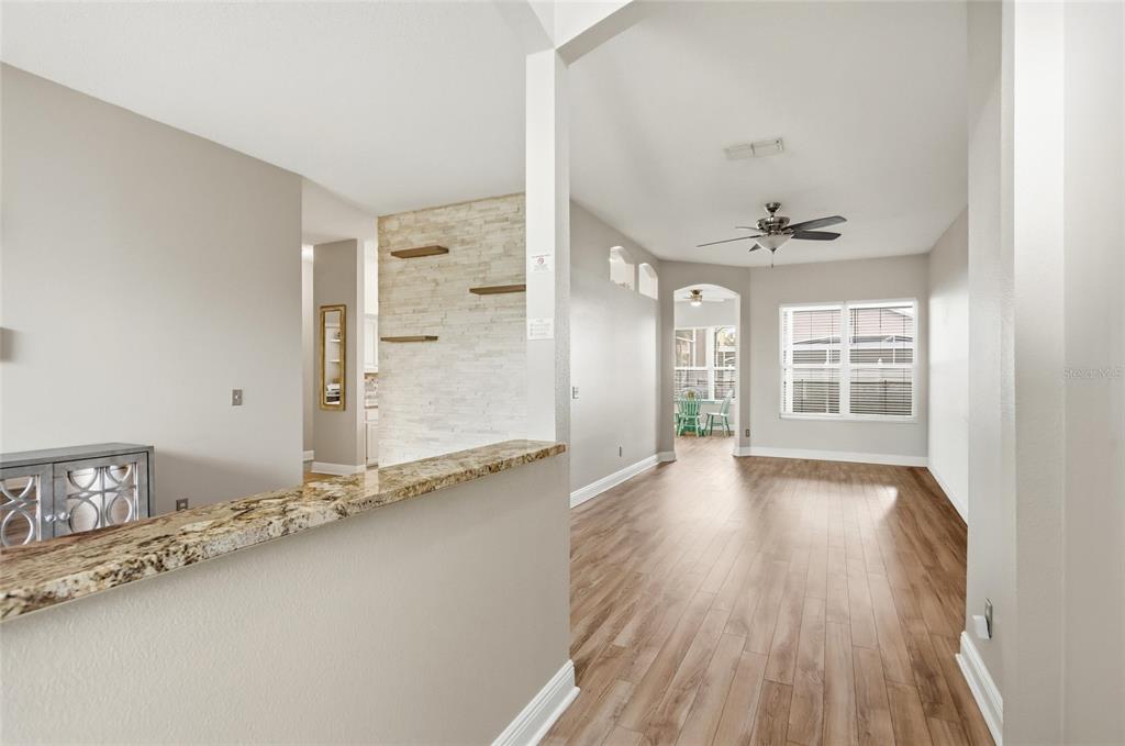 A living area features wood-look flooring, a stone accent wall, and a granite-topped half wall — 340 BALLYSHANNON DRIVE, DAVENPORT, FL