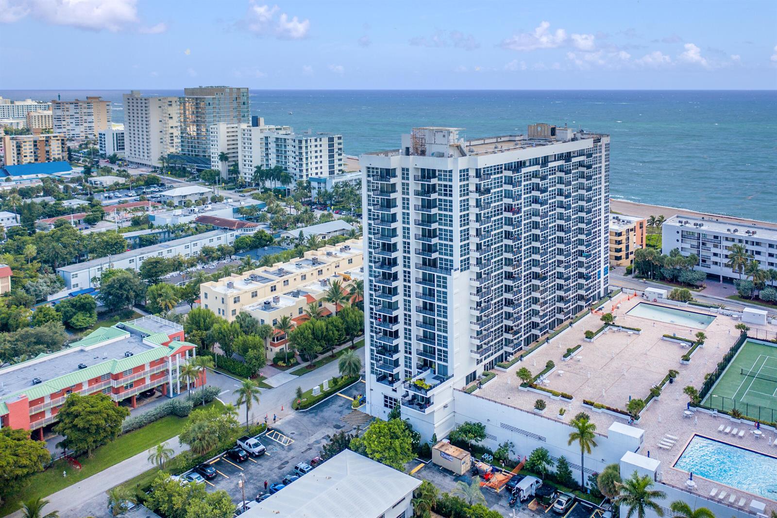 An aerial view shows a tall residential building with a pool and tennis court nearby — 531 N Ocean Boulevard # 1811, Pompano Beach FL 33062, POMPANO BEACH, FL