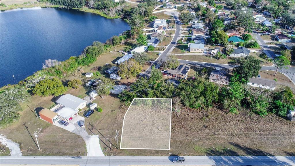 An aerial view shows a vacant, rectangular lot highlighted in white next to a residential house — SR-17 SCENIC HIGHWAY N, HAINES CITY, FL