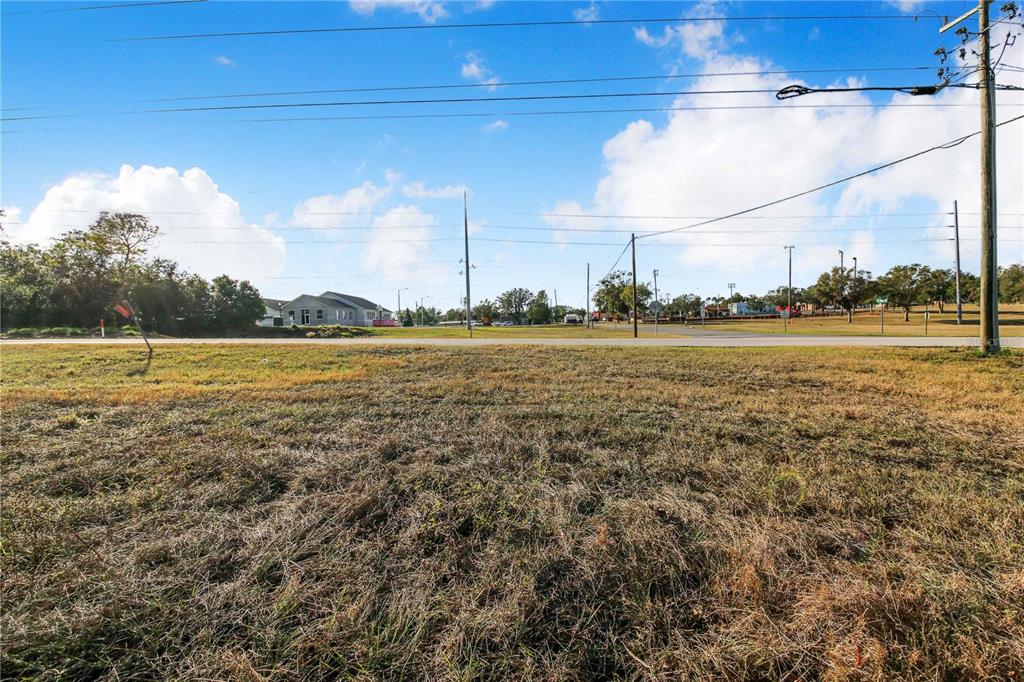 A view of a vacant, grassy lot with a road and utility poles in the background — SR-17 SCENIC HIGHWAY N, HAINES CITY, FL