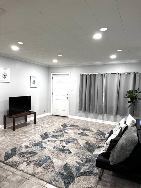 A living room features tile flooring, a large patterned area rug, and recessed ceiling lighting — 5829 12TH STREET, ZEPHYRHILLS, FL
