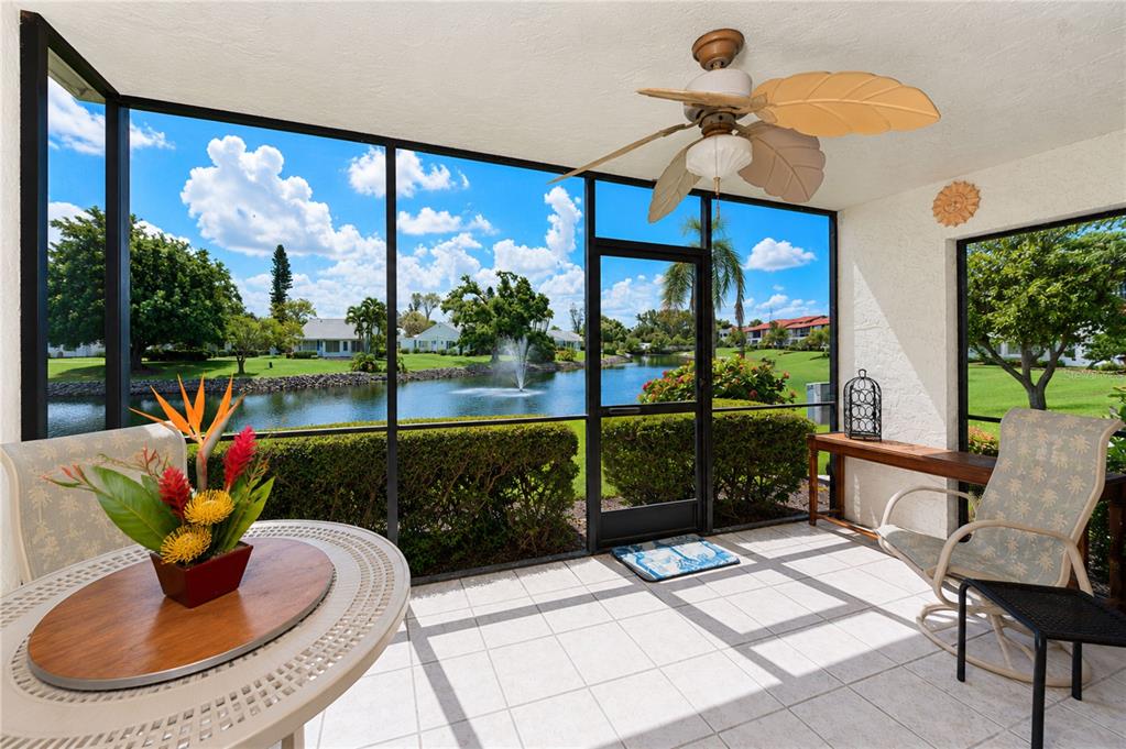 A screened-in patio with tile flooring, a ceiling fan, and a view of a pond — 4853 INDEPENDENCE DRIVE, BRADENTON, FL