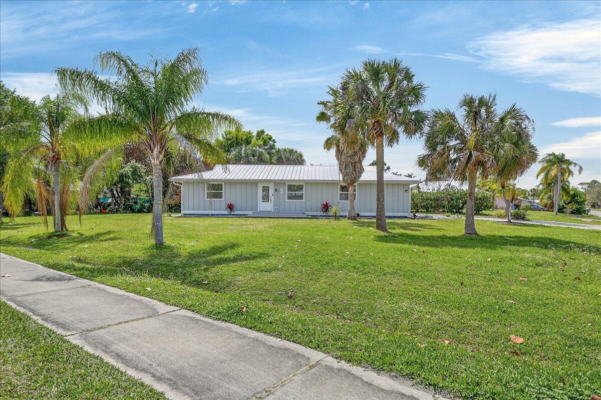 A single-story light gray house with a metal roof sits on a grassy lawn — 262 Easy Street, Sebastian FL 32958, SEBASTIAN, FL