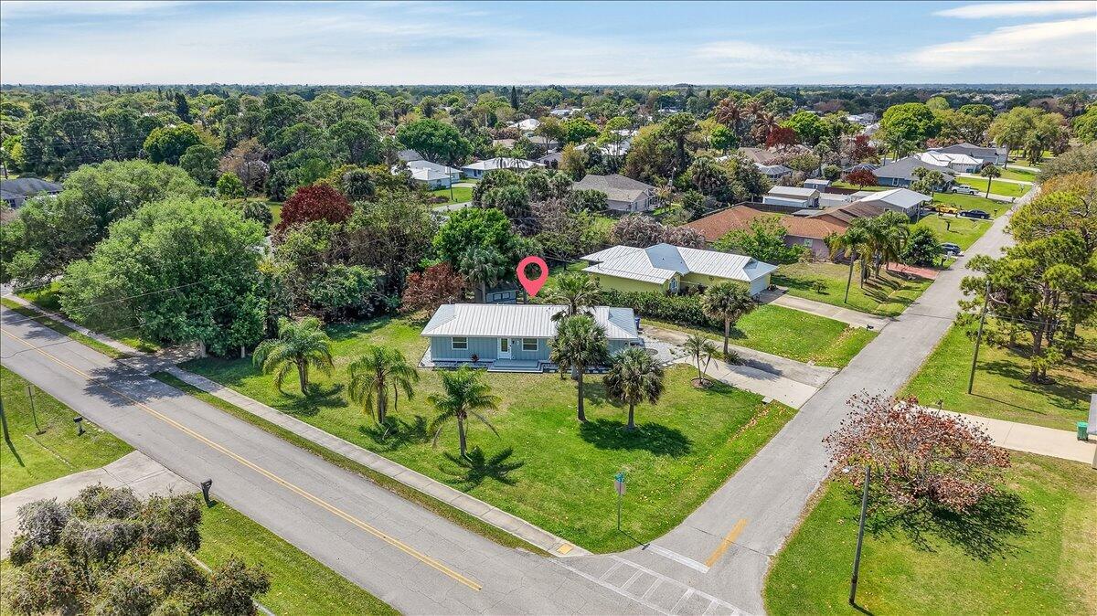 An aerial view of a light blue house with a metal roof and palm trees — 262 Easy Street, Sebastian FL 32958, SEBASTIAN, FL