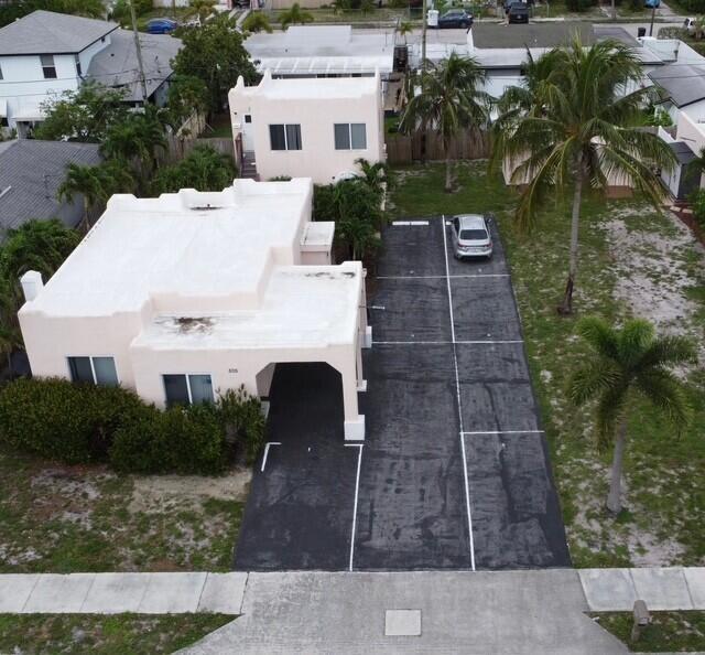 An aerial view shows a light-colored building with a flat roof and a paved parking lot — 505 24th Avenue N, FL 33460, FL