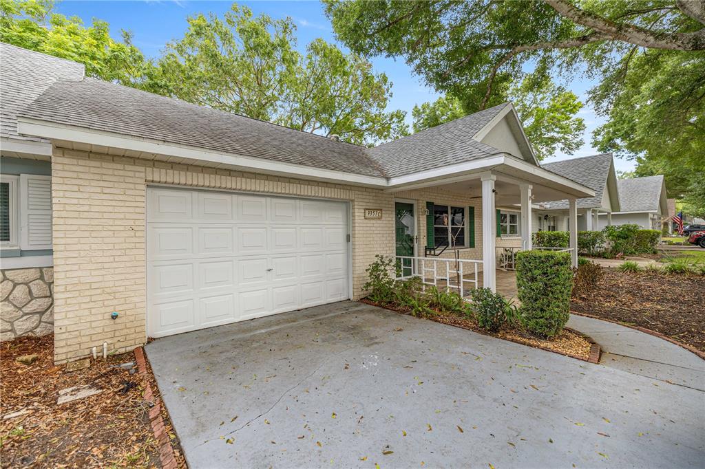 A single-story brick house features a white garage door, a covered porch, and a driveway — 9357 SW 82ND TERRACE UNIT C, OCALA, FL