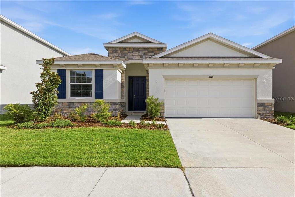 A single-story house with a stone facade, blue shutters, and a two-car garage — 1413 TROPICAL OASIS AVENUE, PLANT CITY, FL
