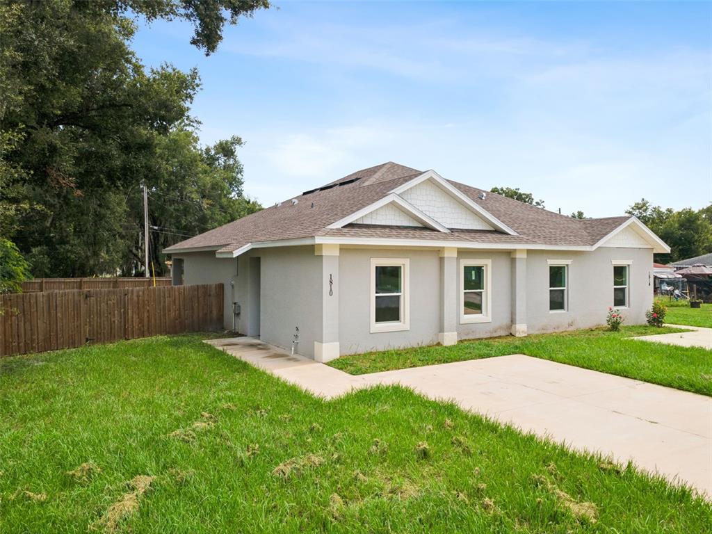 A single-story house with light gray stucco siding and a concrete driveway — 1810 DUNBAR STREET, BARTOW, FL