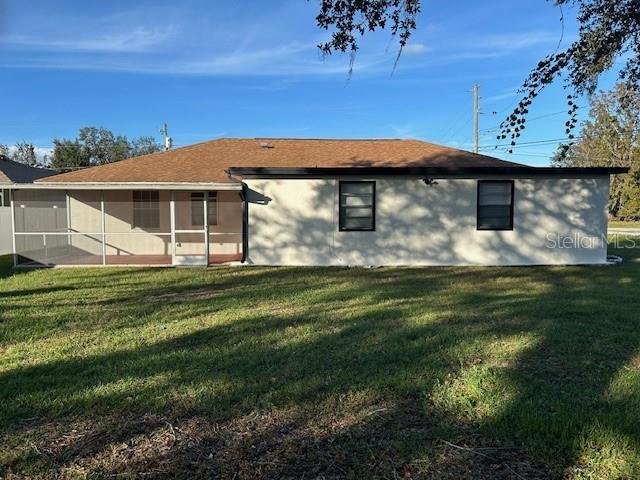 The exterior of a single-story house features a screened-in porch and a tan roof — 602 MESILLA DRIVE, KISSIMMEE, FL