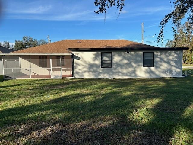 The exterior of a single-story house features a screened-in porch and a brown shingled roof — 602 MESILLA DRIVE, KISSIMMEE, FL
