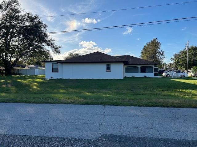 A single-story white house with a dark roof sits on a large grassy lot — 602 MESILLA DRIVE, KISSIMMEE, FL