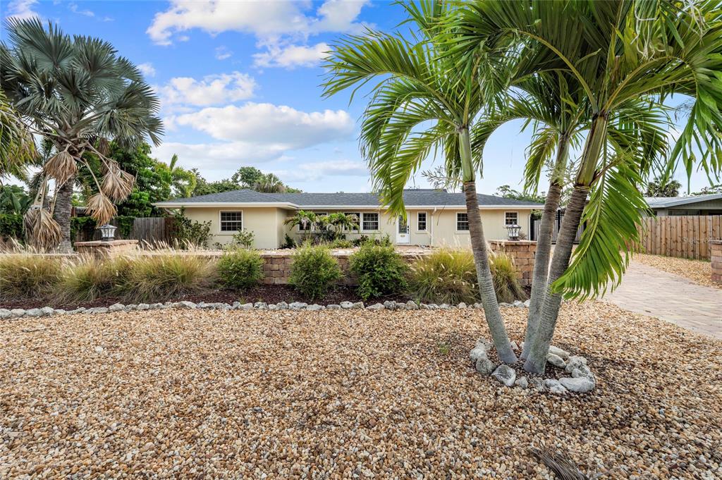 A single-story house with a gravel yard, palm trees, and a low stone retaining wall — 6139 HOLLYWOOD BOULEVARD, SARASOTA, FL