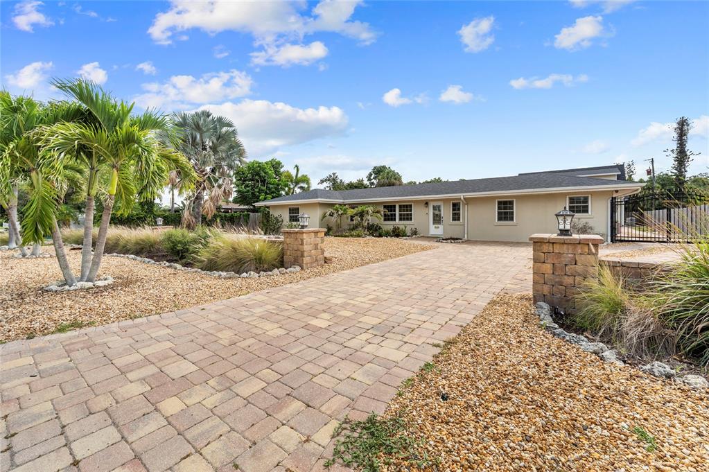 A paved driveway leads to the front entrance of a single-story house with palm trees — 6139 HOLLYWOOD BOULEVARD, SARASOTA, FL