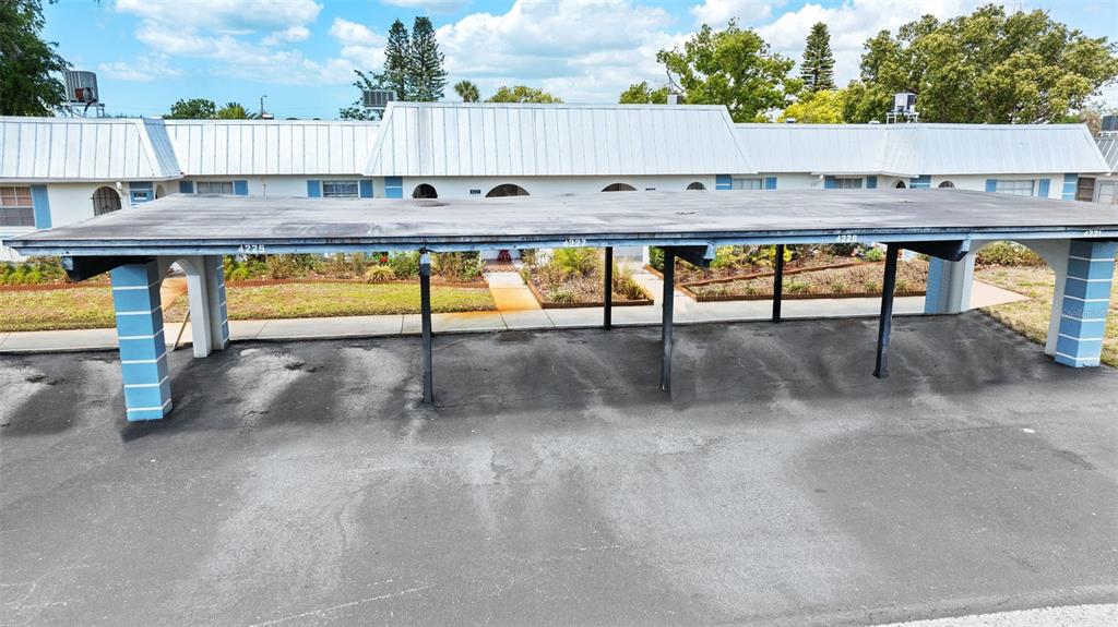 A covered parking carport stands in front of a single-story residential building with white siding — 4227 RAX PLACE UNIT 4227, NEW PORT RICHEY, FL