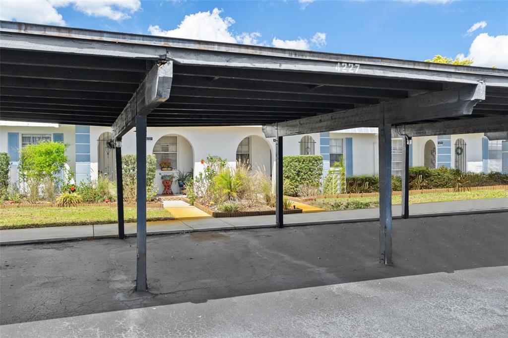 A covered carport structure stands in front of a row of single-story residential units — 4227 RAX PLACE UNIT 4227, NEW PORT RICHEY, FL