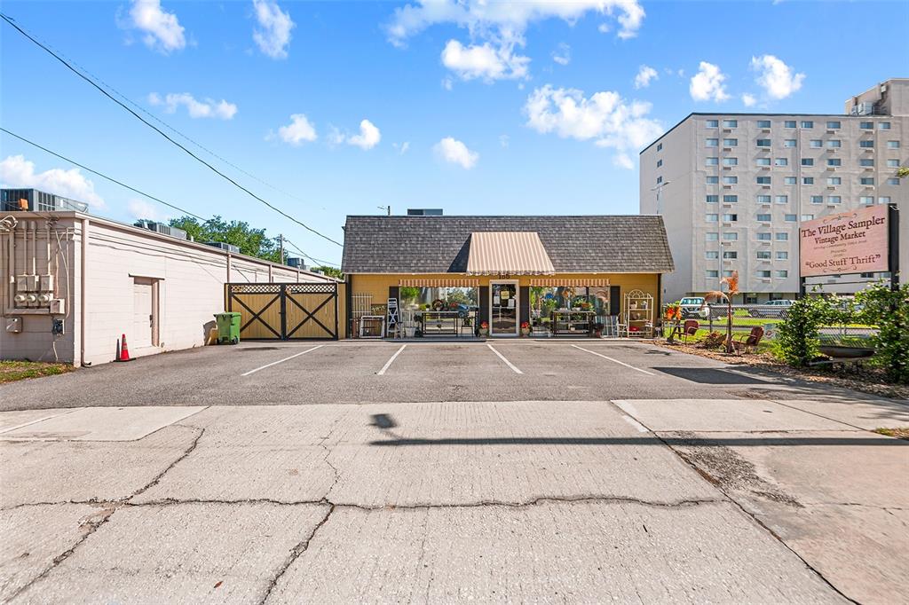 A yellow commercial building with a striped awning and a parking lot in front — 155 AVENUE B SW, WINTER HAVEN, FL