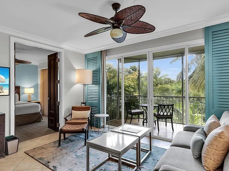 A living room features a ceiling fan, a sofa, a lounge chair, and a balcony view — 81801 Overseas Highway Highway # 714, Islamorada FL 33036, ISLAMORADA, FL