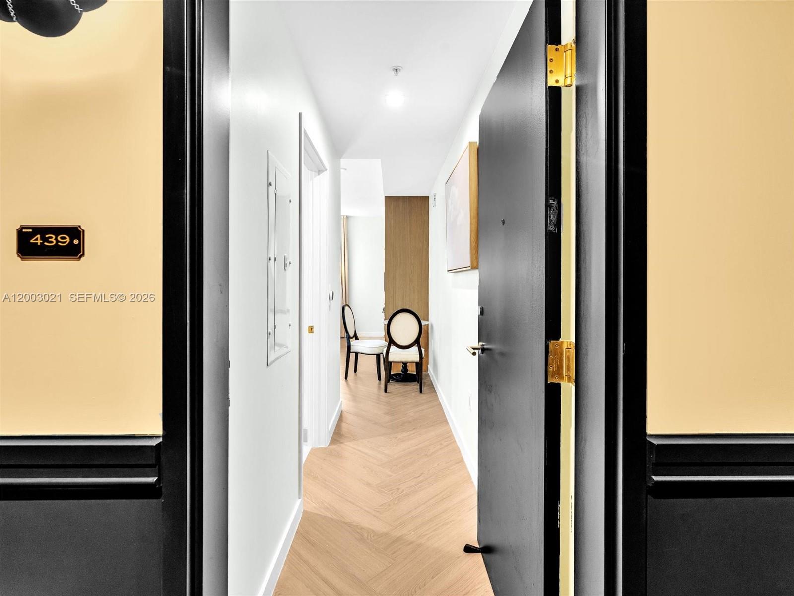 A view through an open doorway into a hallway with herringbone wood flooring — 2700 NW 2nd Ave # 439, Miami FL 33127, MIAMI, FL