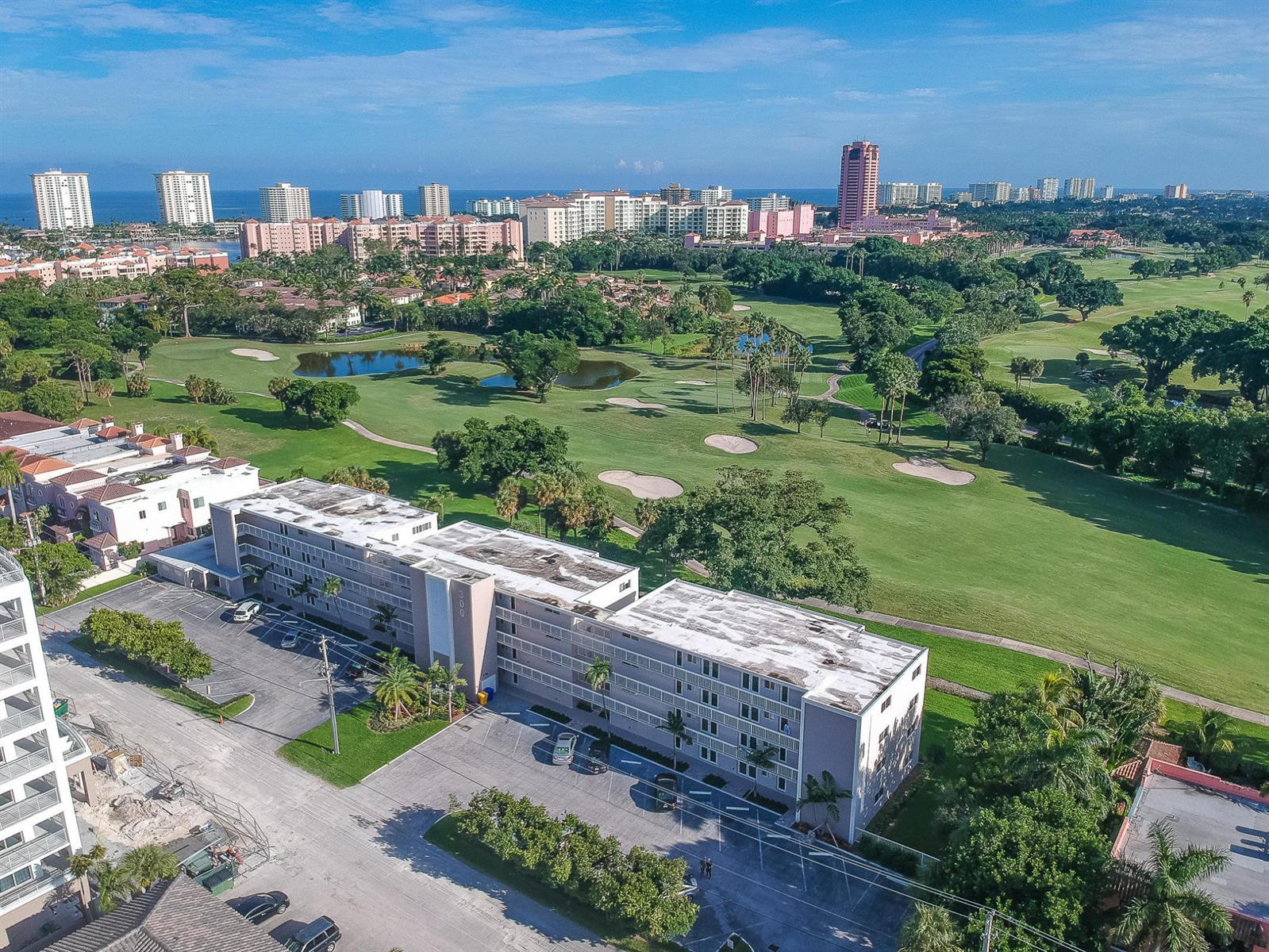 An aerial view shows a multi-story apartment building adjacent to a large golf course — 300 E Royal Palm Road # 0420, Boca Raton FL 33432, BOCA RATON, FL