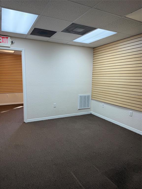 An interior office space features beige walls, brown carpeting, slat wall panels, and drop ceilings — 4022 LAND O LAKES BOULEVARD UNIT 101, LAND O LAKES, FL