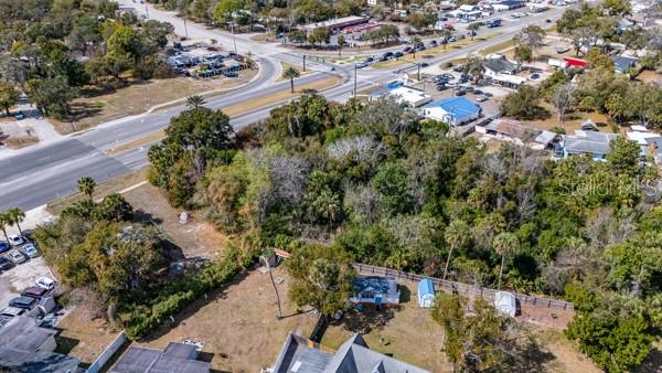 An aerial view shows a wooded lot adjacent to a road and residential properties — 5919 S RIDGEWOOD AVENUE, PORT ORANGE, FL