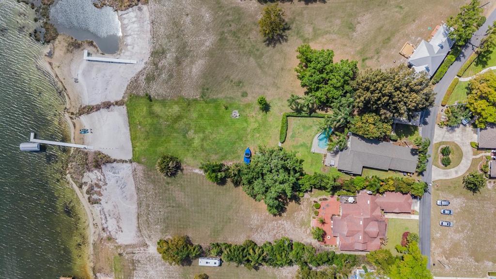Aerial view of a waterfront property featuring a house, pool, lawn, and two boat docks — 1238 S HIGHLAND PARK DRIVE, LAKE WALES, FL