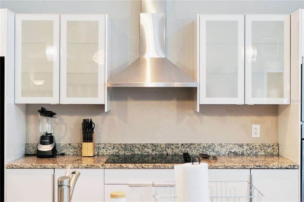 A modern kitchen features white cabinets, a stainless steel range hood, and granite countertops — 5417 PITCH PINE DRIVE, ORLANDO, FL