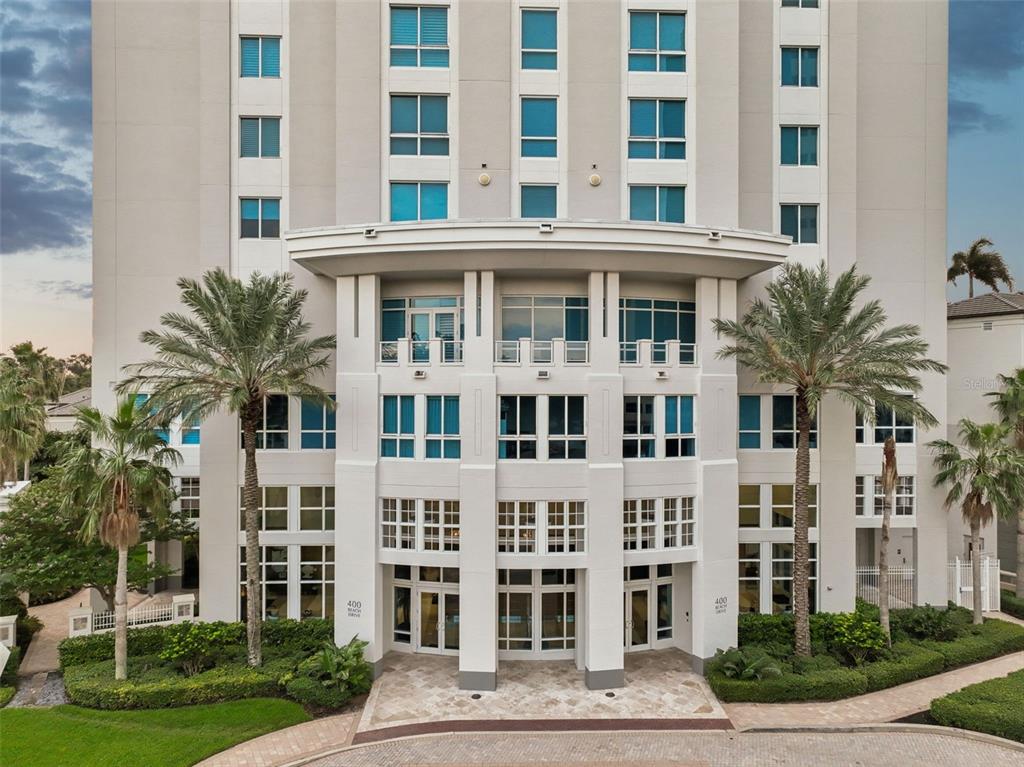 The exterior of a multi-story residential building features a stone entrance and two palm trees — 400 BEACH DRIVE NE UNIT 2605, ST PETERSBURG, FL