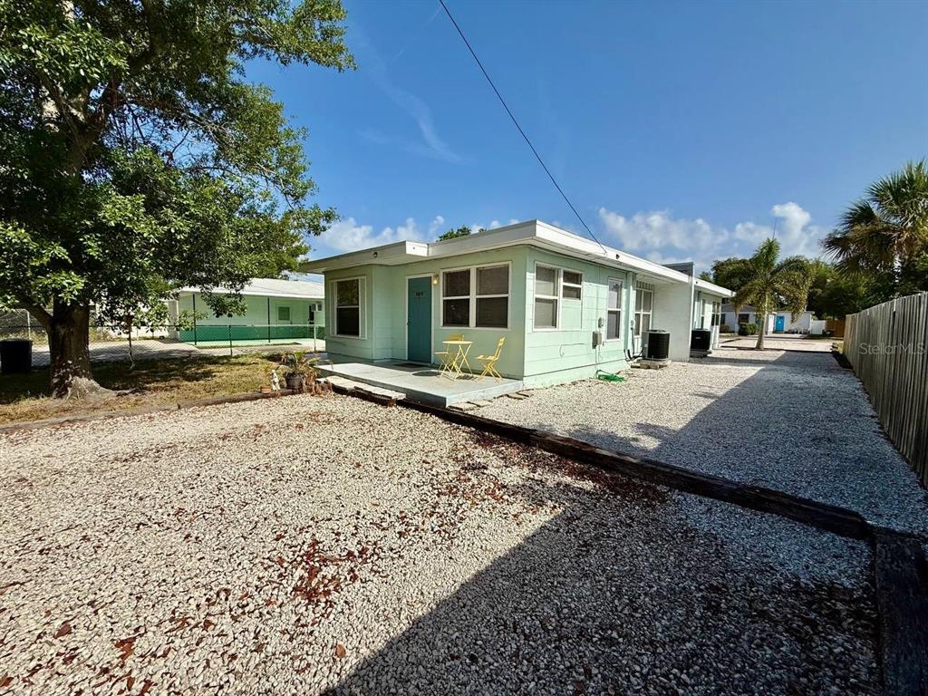 A light green single-story house with a gravel driveway and a small concrete patio — 5612 18TH AVENUE S, ST PETERSBURG, FL