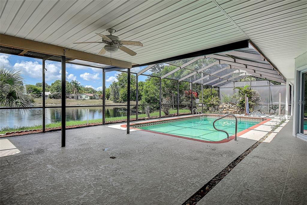 Aerial view of three suburban houses with swimming pools situated along a small lake — 2876 LAKE VALENCIA BOULEVARD E, PALM HARBOR, FL