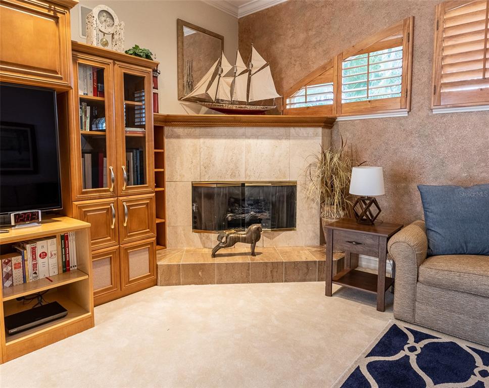 A living room features a corner fireplace with tile surround, built-in cabinetry, and a model ship — 17479 OHARA DRIVE, PORT CHARLOTTE, FL