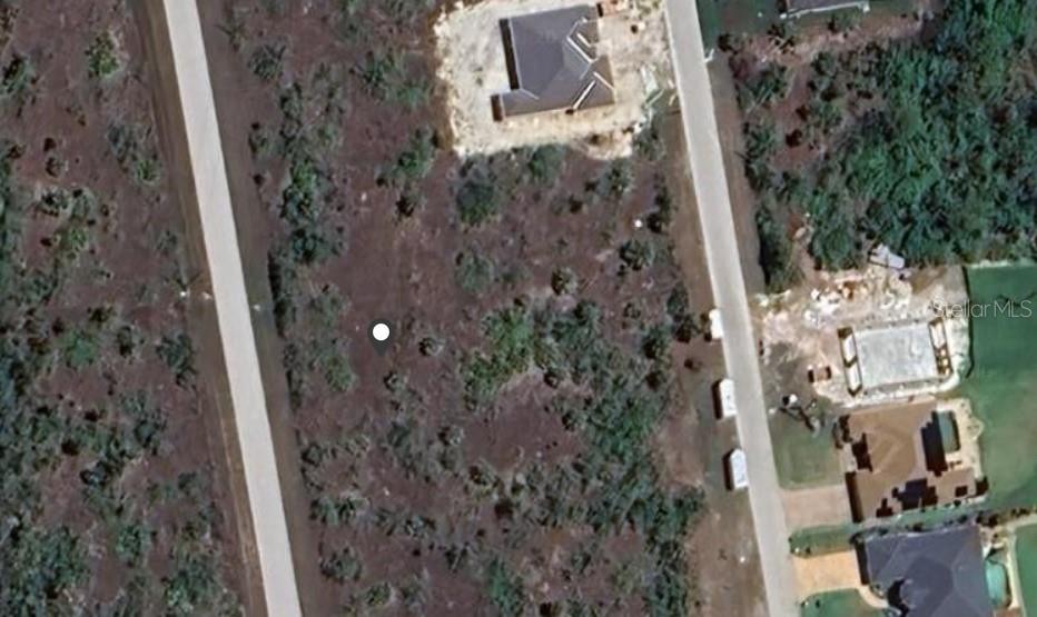 This aerial view shows a vacant residential lot situated between two paved roads — 9813 SHELBURNE CIRCLE, PORT CHARLOTTE, FL