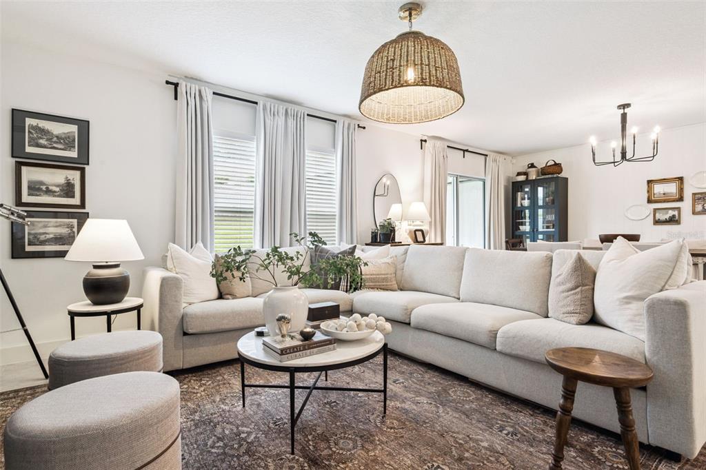A living room features a large sectional sofa, a round coffee table, and a woven pendant — 1657 WILSON PRAIRIE CIRCLE, GROVELAND, FL