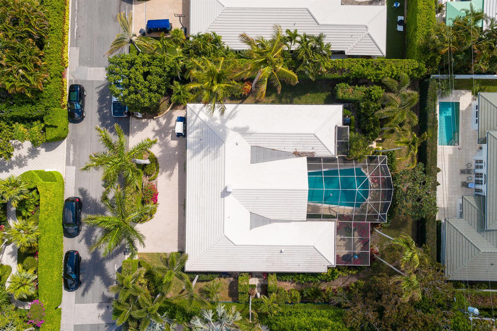 An aerial view shows a house with a white roof, a screened pool, and landscaping — 280 Tradewind Drive, Palm Beach FL 33480, PALM BEACH, FL