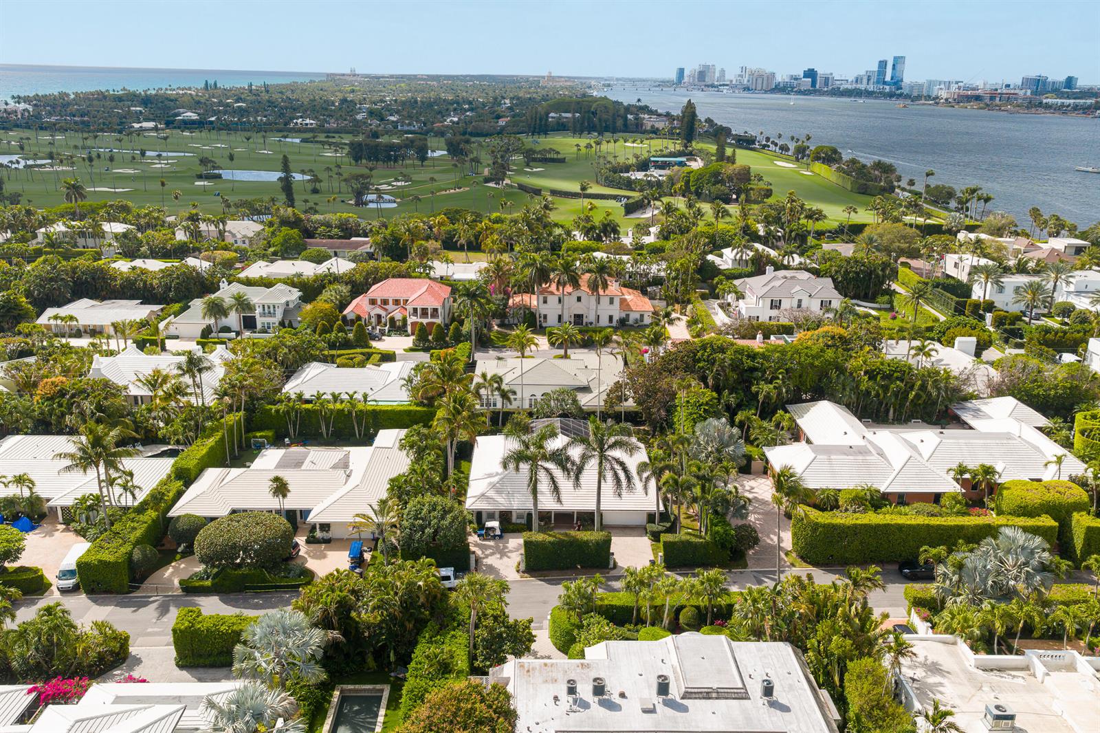 An aerial view shows a residential neighborhood with lush landscaping, swimming pools, and a golf course — 280 Tradewind Drive, Palm Beach FL 33480, PALM BEACH, FL