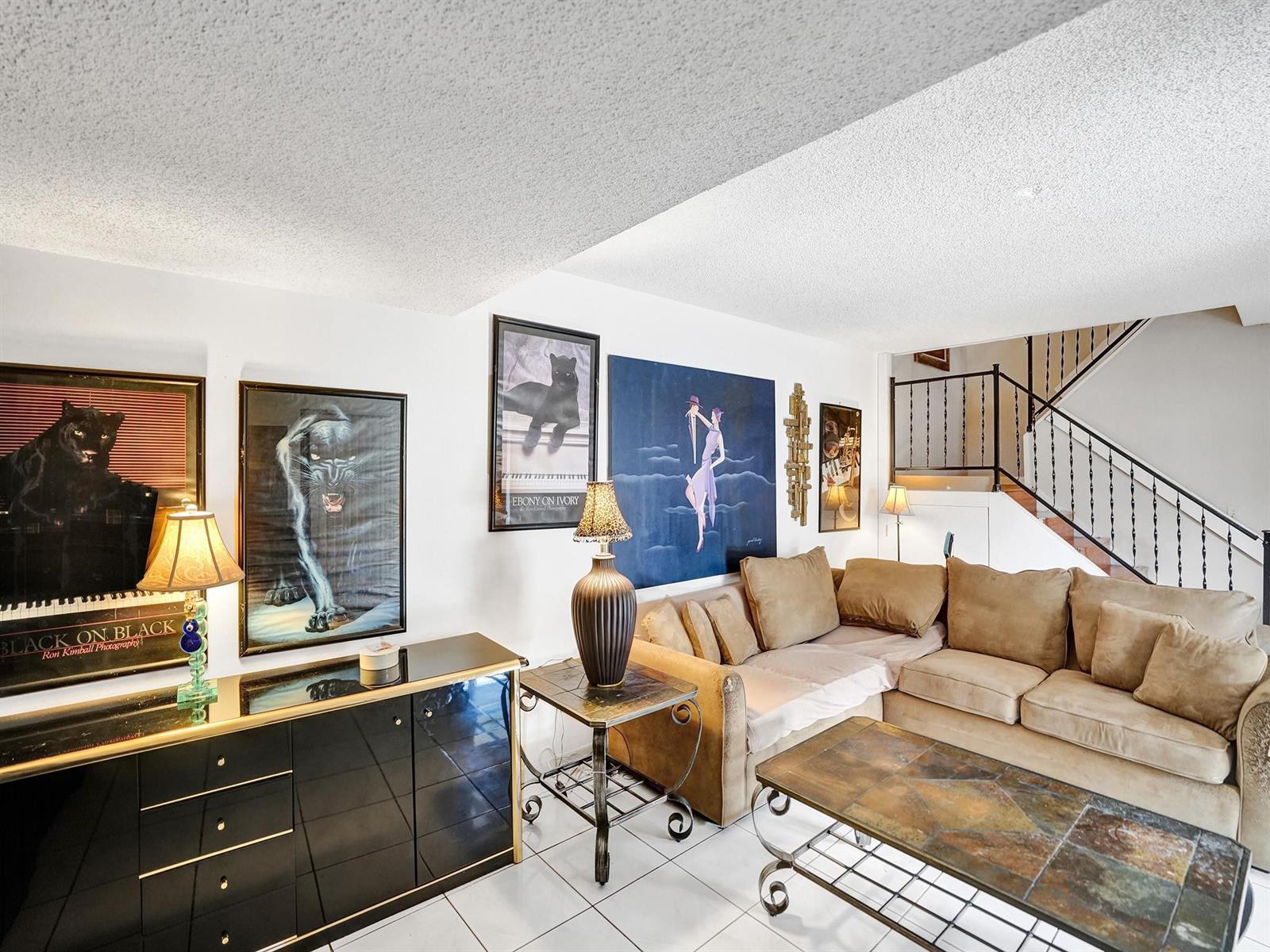 A living room features a black sideboard, a tan sectional sofa, and several panther-themed artworks — 865 NW 29th Avenue # A, Delray Beach FL 33445, DELRAY BEACH, FL