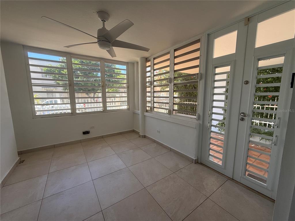 A sunroom features large louvered windows, white tile flooring, and a ceiling fan — 1510 LAS MARÍAS ST., SAN JUAN, PR