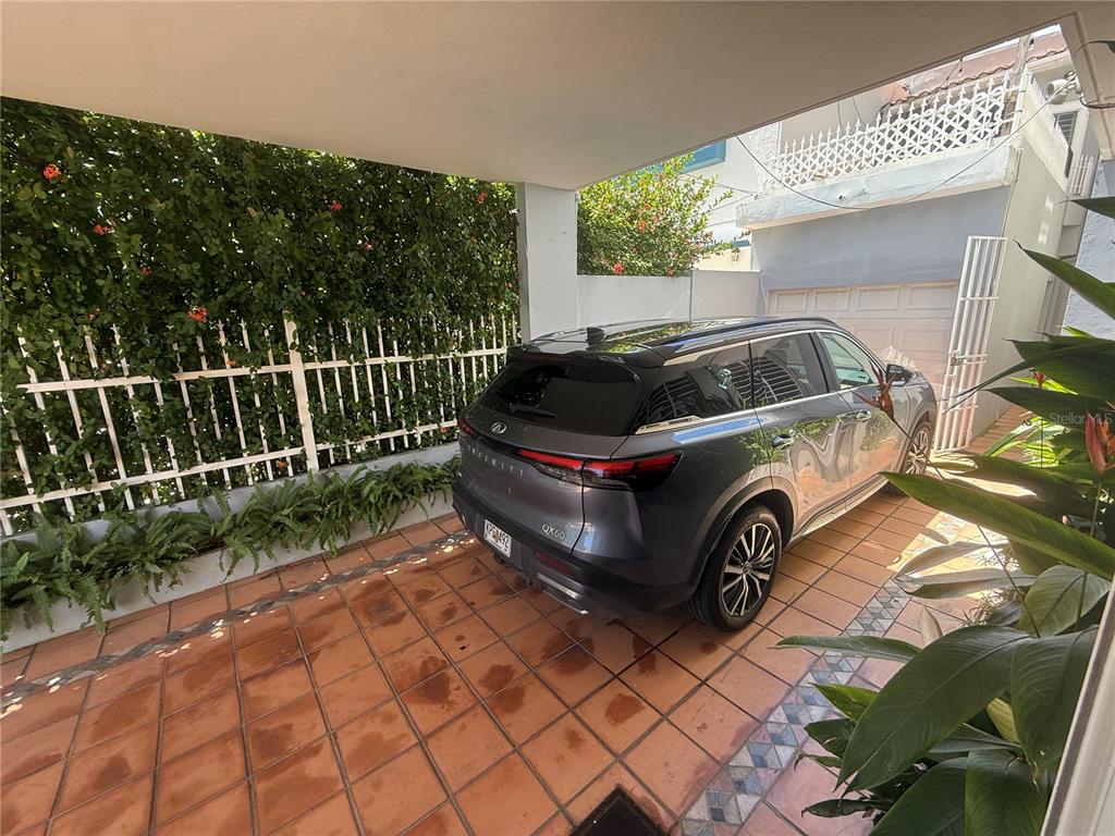 A gray Infiniti SUV is parked under a covered carport with terracotta tile flooring — 1510 LAS MARÍAS ST., SAN JUAN, PR