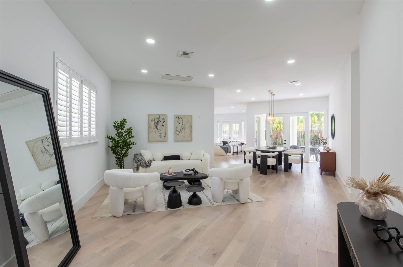 A bright, open-concept living and dining area features white walls, light wood floors, and modern furniture — 2443 Players Ct, Wellington FL 33414, WELLINGTON, FL