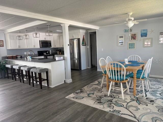 A kitchen with a breakfast bar and a dining area featuring a patterned rug — 264 PHILADELPHIA BOULEVARD UNIT 51, PALM HARBOR, FL