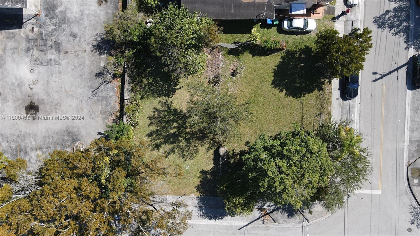 An aerial view shows a vacant, tree-covered residential lot situated between a parking lot and street — 3373 Thomas Ave, Miami FL 33133, MIAMI, FL