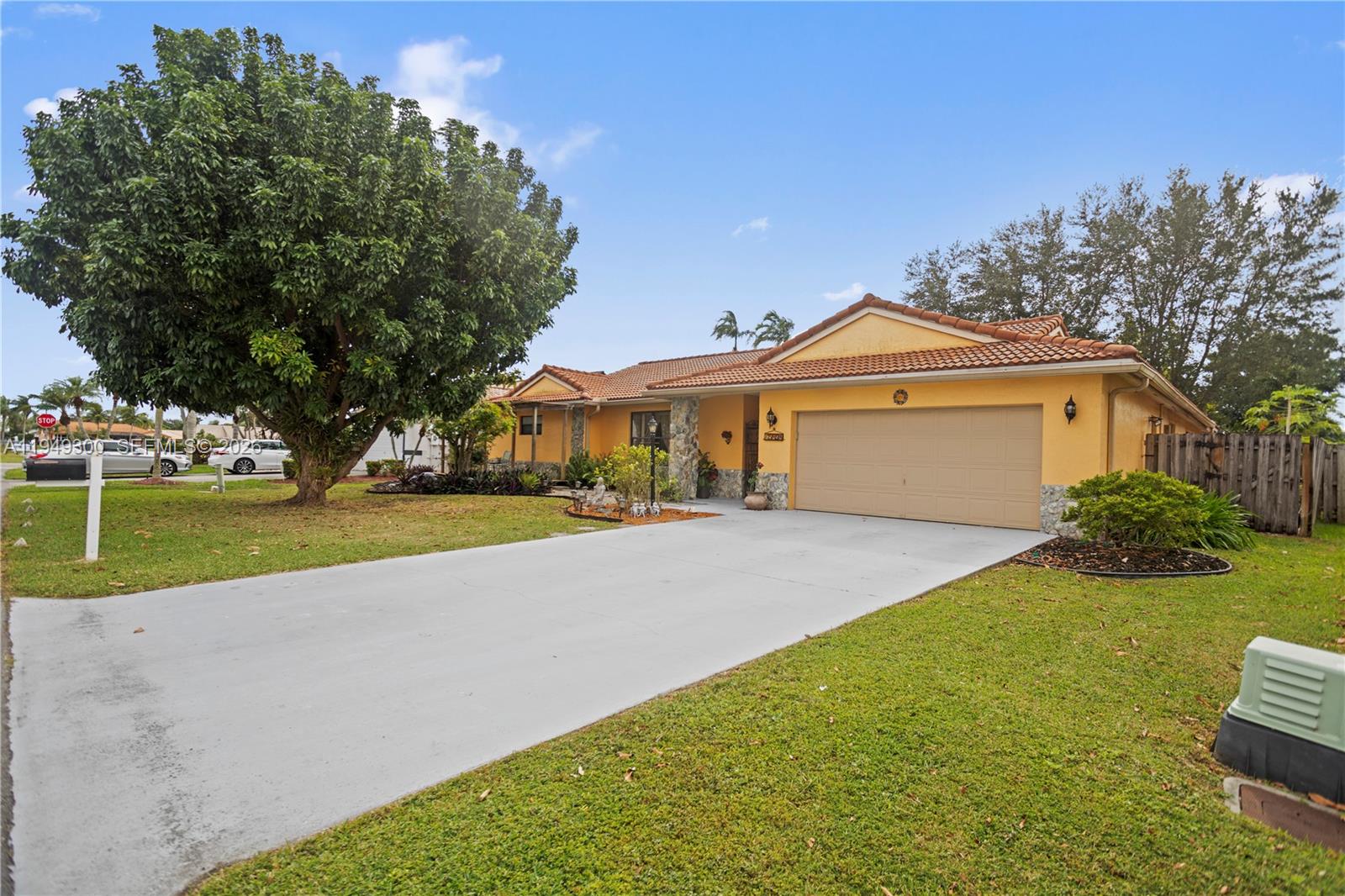 A single-story yellow house with a tile roof and a concrete driveway — 15824 Cotswold Ct, Davie FL 33331, DAVIE, FL