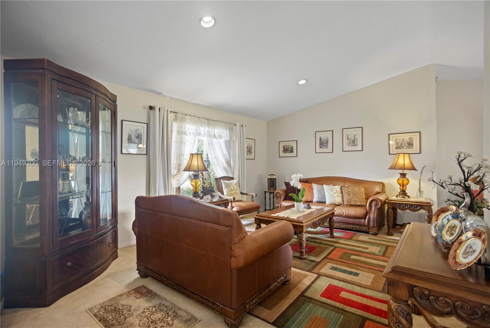 A living room features leather furniture, a patterned area rug, and a large wooden cabinet — 15824 Cotswold Ct, Davie FL 33331, DAVIE, FL